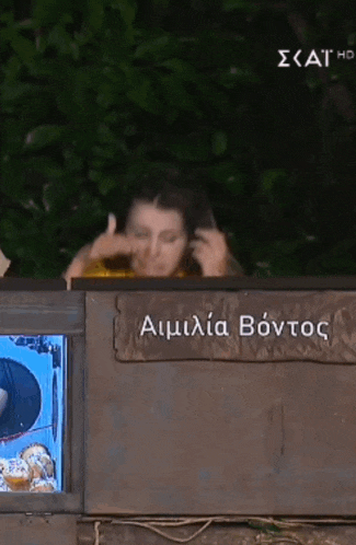 a woman is sitting in front of a sign that says ' amilia bontos '
