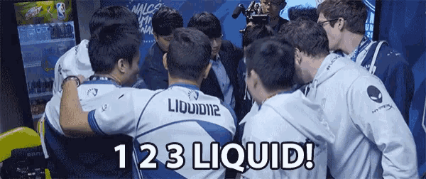 a group of men are huddled together with liquid12 on the back of their shirts