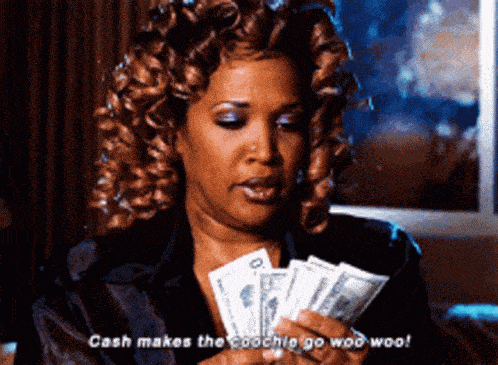 a woman with curly hair is holding a fan of money and says cash makes the coachie go woo woo