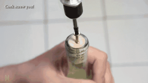 a person is using a drill to drill a hole in a glass bottle