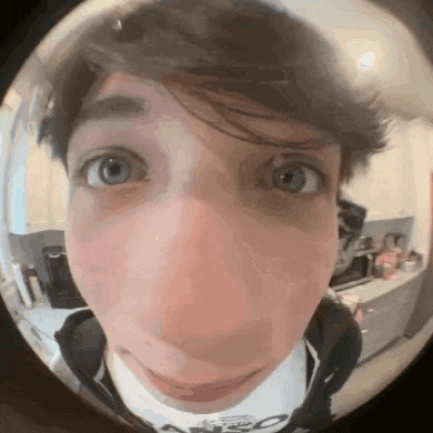 a close up of a person 's face with a fisheye lens looking at the camera .