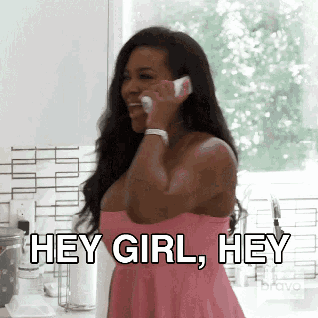 a woman in a pink dress is talking on a cell phone and the words hey girl hey are above her