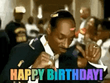 snoop dogg is wearing a suit and tie and smoking a cigarette and says `` happy birthday '' .