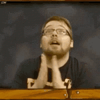 a man with glasses and a beard is praying in front of a chalkboard .