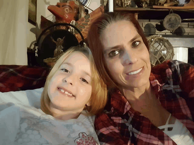 a woman and a little girl pose for a picture