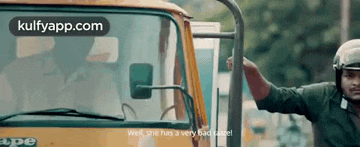 a man wearing a helmet is standing next to a truck .
