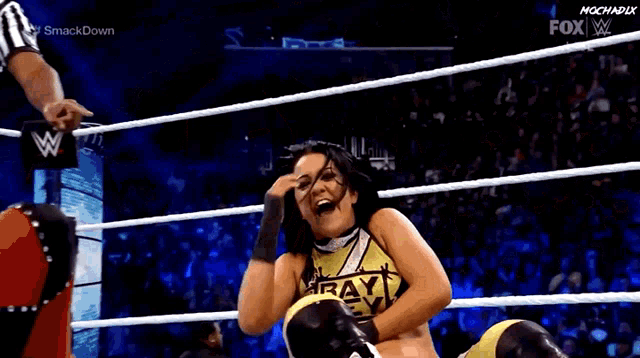 a woman in a wrestling ring with her mouth open and a crowd watching .
