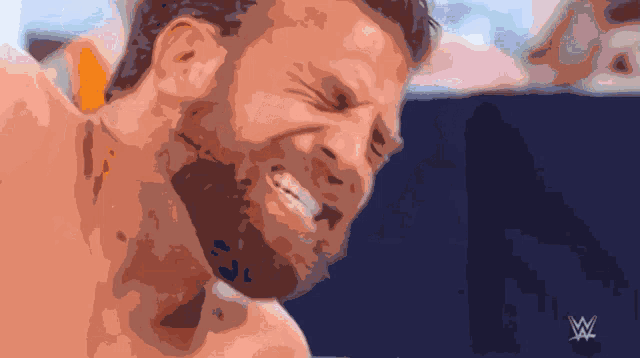 a man with a beard is smiling with a w logo in the corner