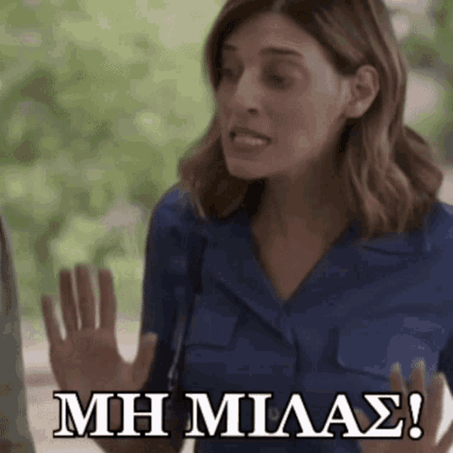a woman in a blue shirt is making a funny face with the words mh milas written below her