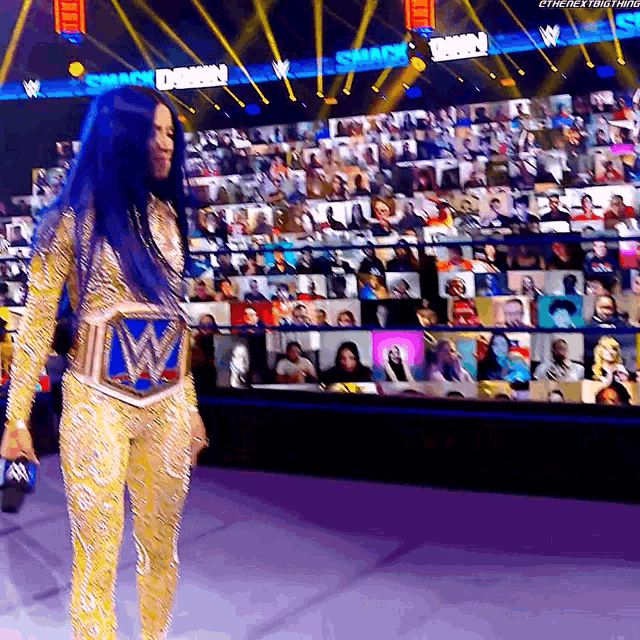 a woman stands in front of a large screen that says smackdown on it