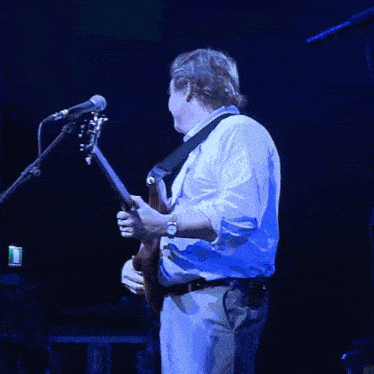 a man is playing a bass guitar with a ring on his finger
