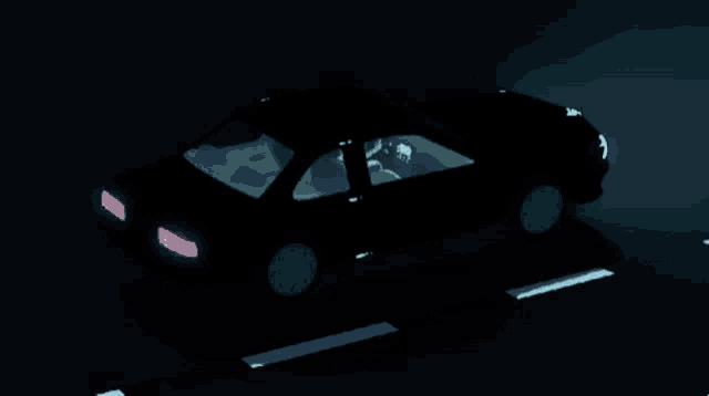 a car is driving down a road at night with the lights on