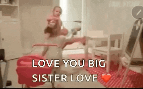 a little girl is holding a baby in her arms in a living room .