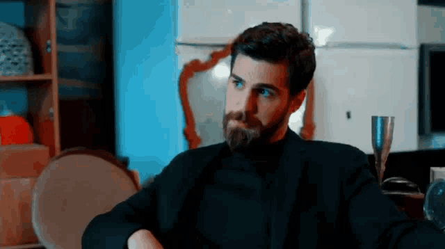 a man with a beard is wearing a black shirt