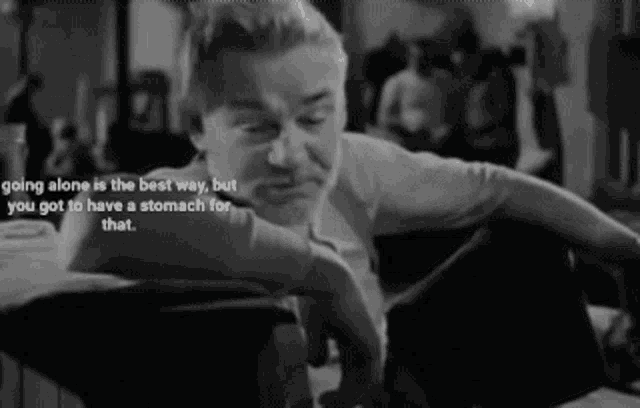 a black and white photo of a man sitting at a table