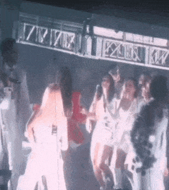 a group of people are dancing on a stage in a club .