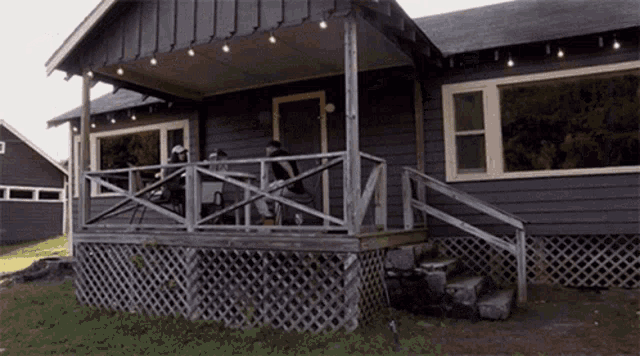 people sitting on a porch of a house