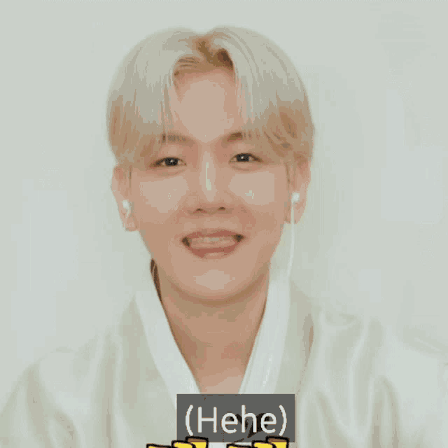 a young man wearing ear buds is smiling with the words ( hee ) above his head