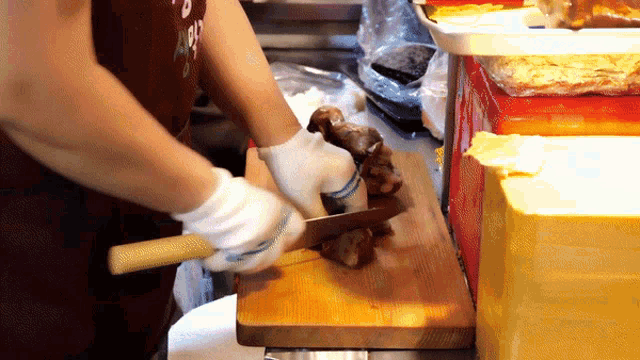 a person cutting a piece of meat on a cutting board
