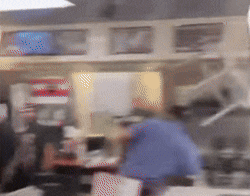 a blurry picture of people in a restaurant with a sign that says ' coca cola ' on it