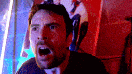 a man with a beard is screaming with his mouth open