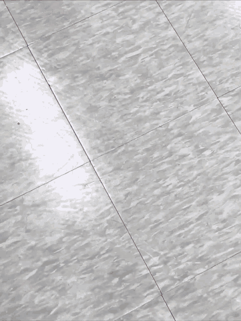 a person laying on a gray tiled floor