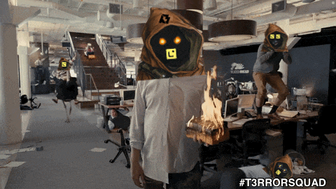 a man with a mask on his head is standing in an office with #t3rrorsquad written on the bottom right