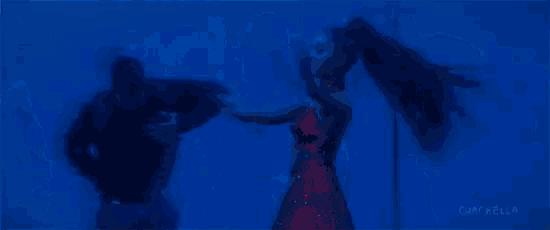 a man and a woman are dancing in a blue light .