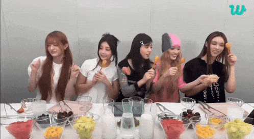 a group of girls are sitting at a table eating food