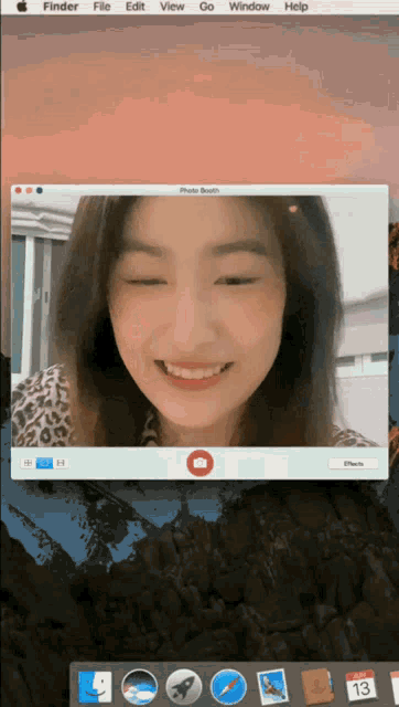 a woman is smiling in a photo booth window on a mac