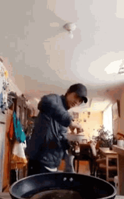 a man is standing in front of a frying pan