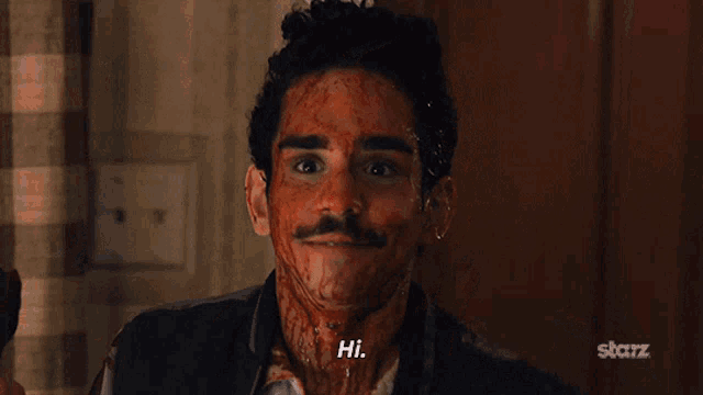 a man with blood on his face is smiling and holding a bottle with the word hi on it