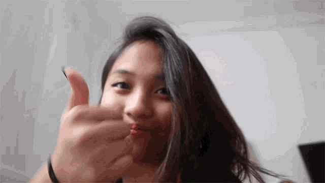 a woman giving a thumbs up sign with her hand
