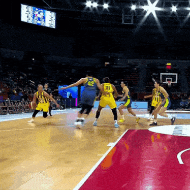 a basketball player with the number 18 on his back dribbles the ball