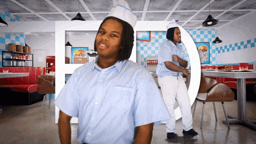 a man in a diner wearing a white hat and a blue and white striped shirt