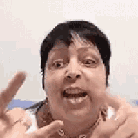 a woman is making a funny face with her mouth open and her hands out .