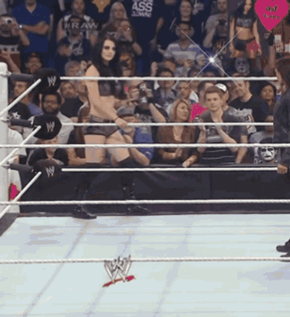 a woman in a wrestling ring with a crowd behind her and a sign that says raw