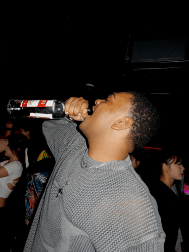 a man is singing into a microphone with a sticker on it that says ' coca cola '