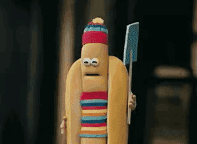 a cartoon hot dog is holding a knife and wearing a hat and striped scarf .