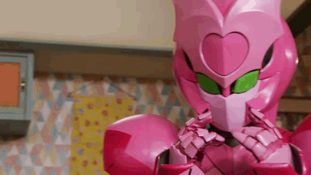 a pink robot with green eyes and a heart shaped head