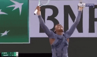 a woman is holding a tennis racquet in front of a bnp ad