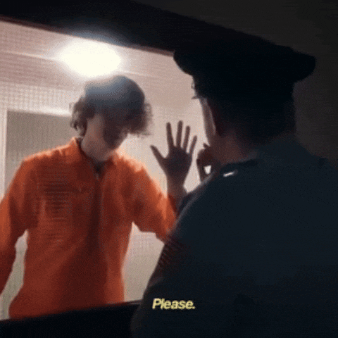 a man in an orange jumpsuit is talking to a police officer who is asking him to please