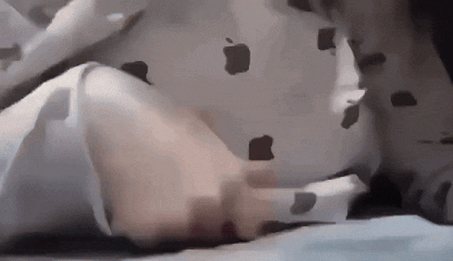 a person laying on a bed with an apple on their shirt .