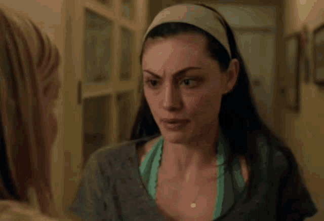 a woman with a headband on her head looks at another woman