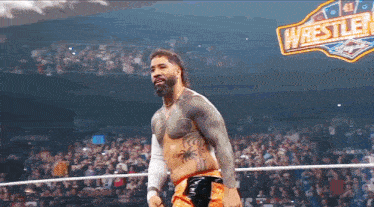 a man in a wrestling ring with a sign that says wrestler on it .