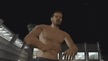 a man in a tank top is sitting on the floor