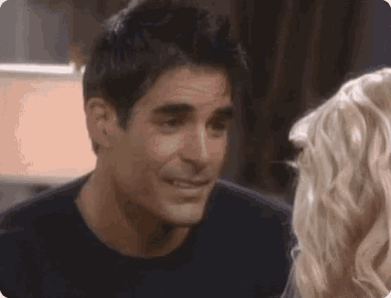 a man and a woman are looking at each other in a room .