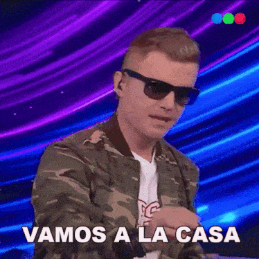 a man wearing sunglasses and a camo jacket says " vamos a la casa "