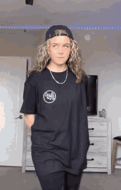 a woman wearing a hat and a t-shirt with a circle on the front that says u.s.