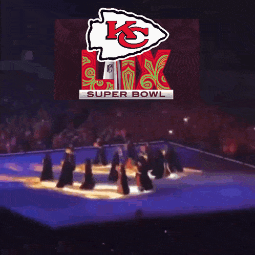 a group of people dancing in front of a super bowl logo